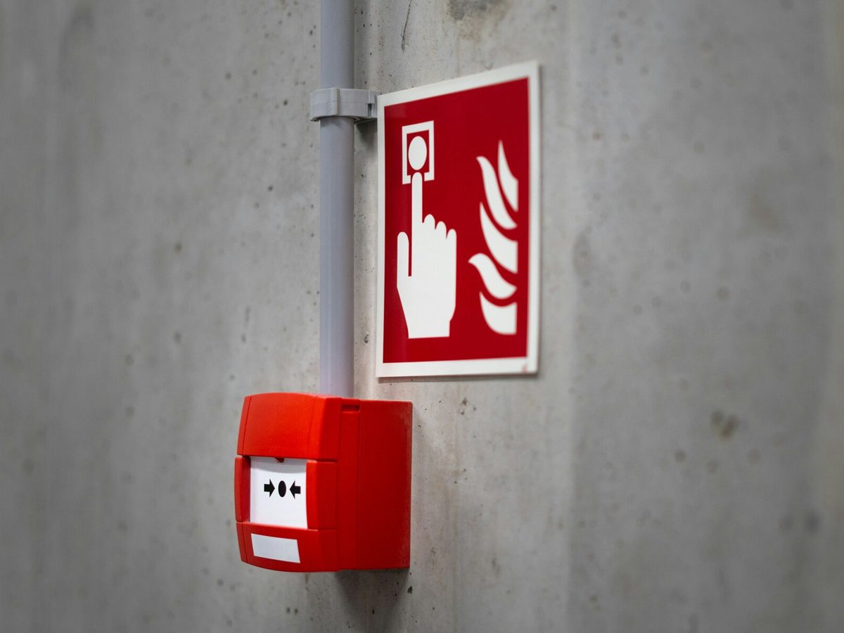 A fire alarm call point and sign on a wall