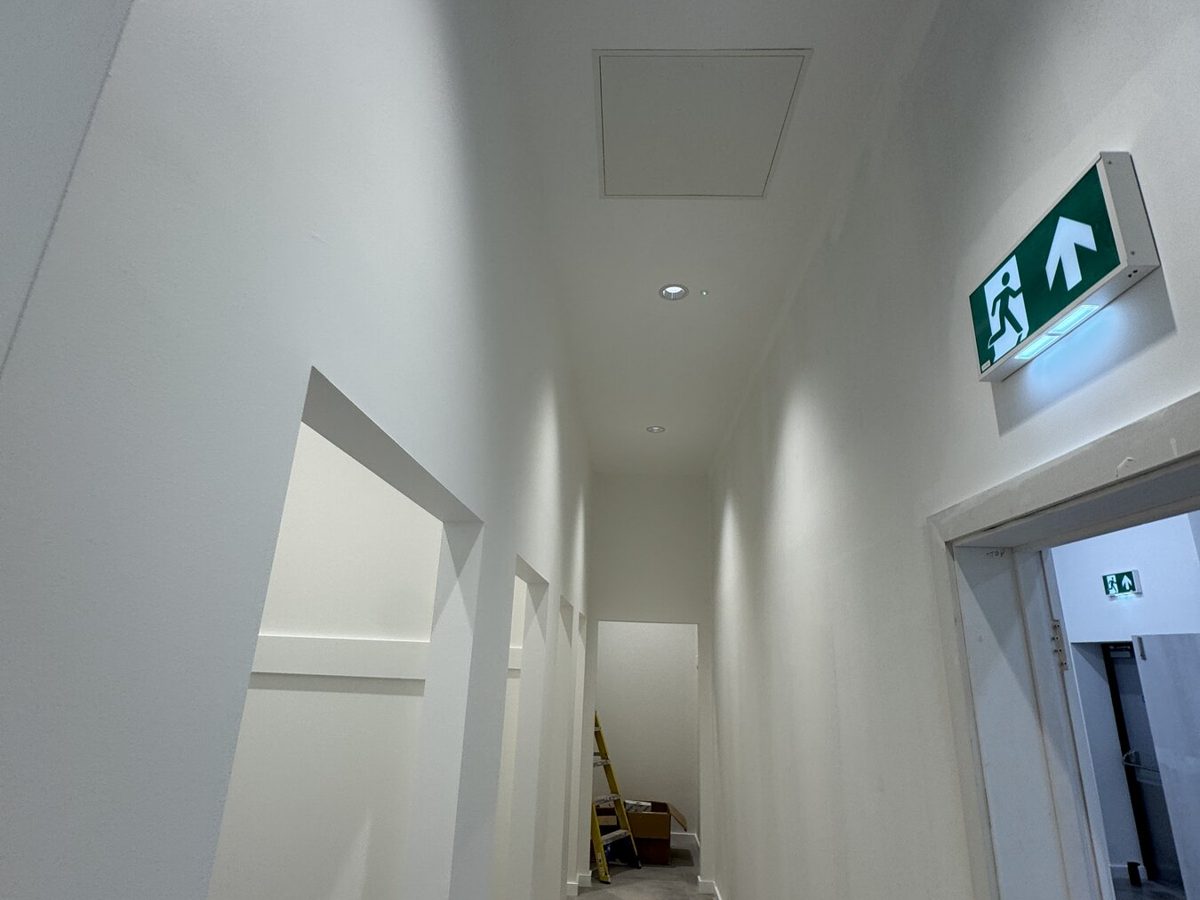 A corridor with an illuminated exit sign