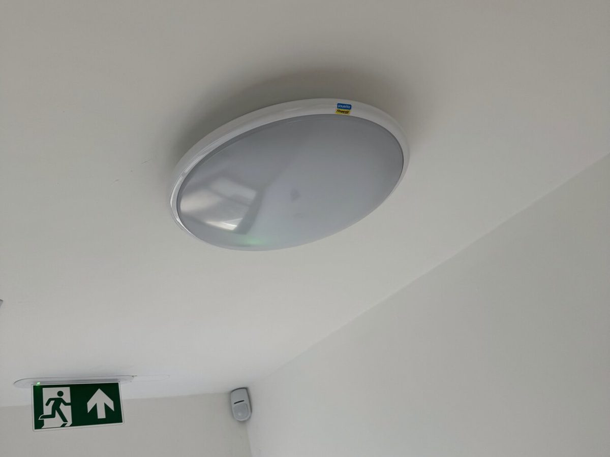 An emergency bulkhead and exit sign above a door