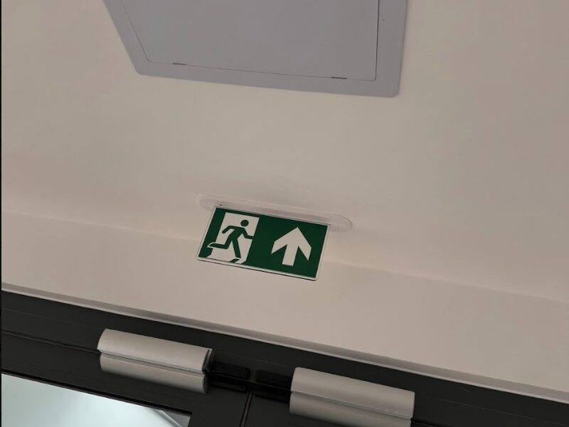 An emergency exit sign above a fire door