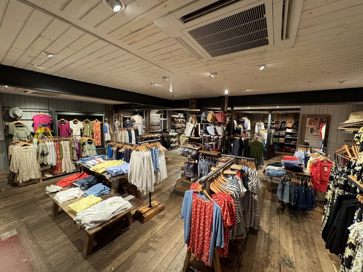 A FatFace shop floor with rails of clothing under the lighting