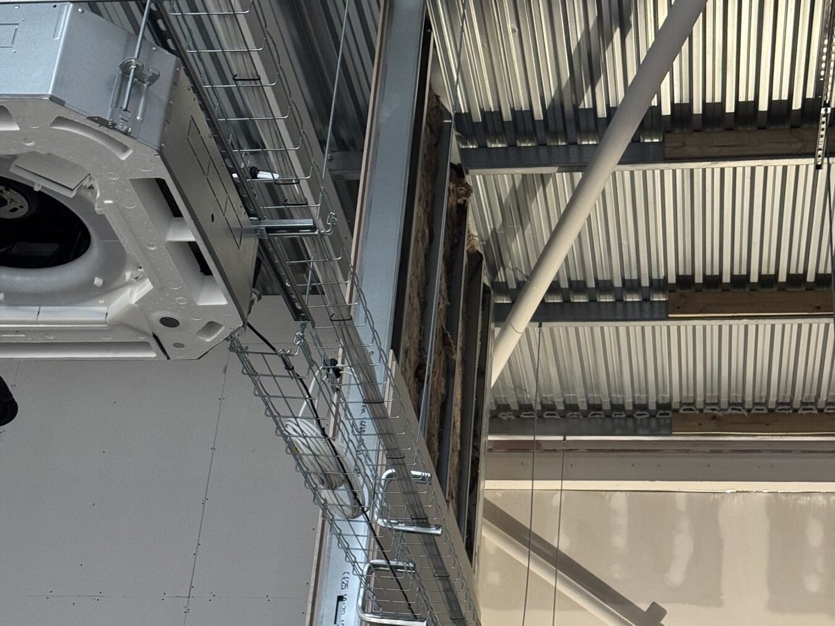 Cable tray and first-fix wiring run to a ceiling cassette before the ceiling is closed